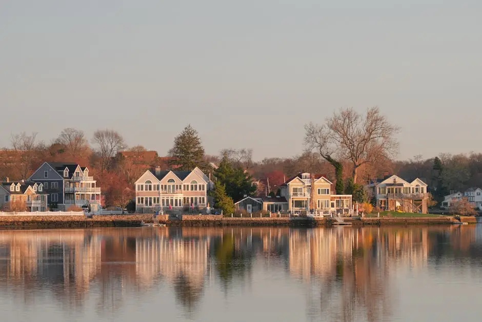 Scenic view of waterfront homes in Stamford, Connecticut at sunrise, with reflections on calm waters.