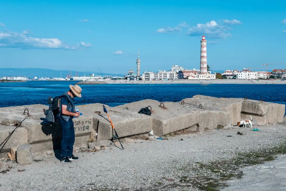A traveler with a backpack and hat explores a coastal area with a lighthouse and clear blue skies.