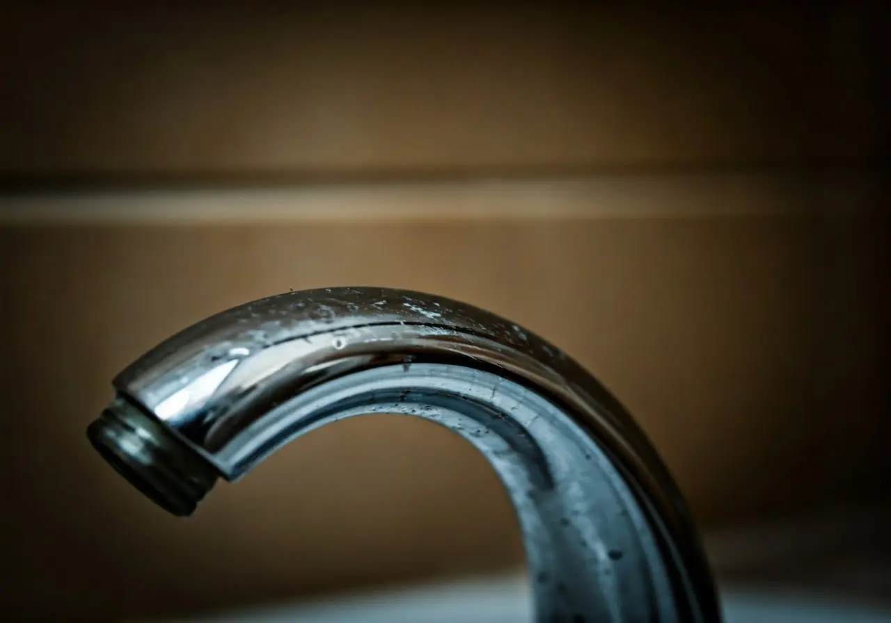 A close-up of hard water stains on a bathroom faucet. 35mm stock photo