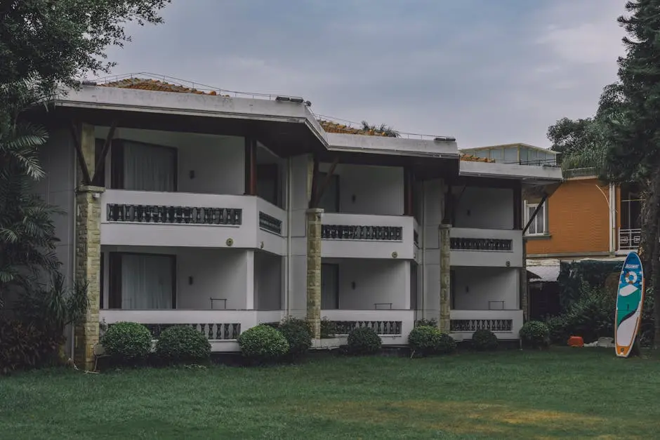 A stylish apartment building featuring balconies and a manicured lawn.