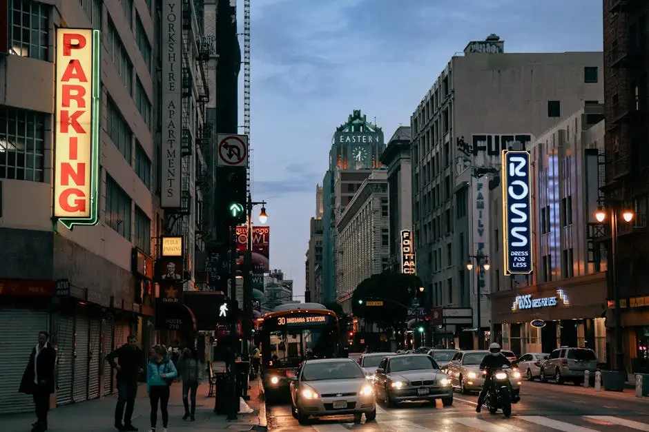 City life in downtown Los Angeles with traffic and pedestrians at dusk.
