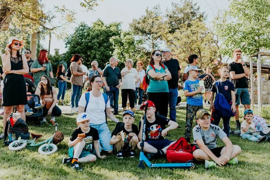 A diverse group of people enjoying a sunny day at an outdoor community event in a park setting.