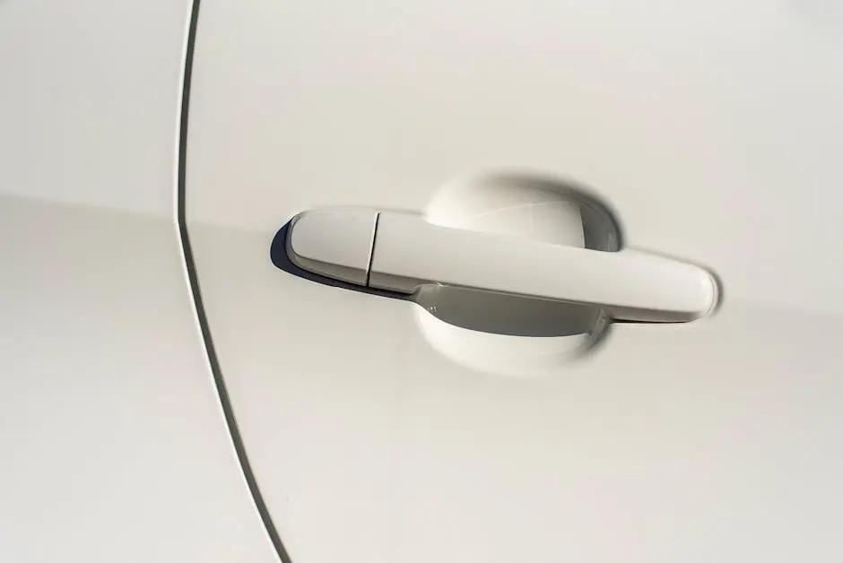 Minimalist close-up view of a sleek white car door handle highlighting the modern design.