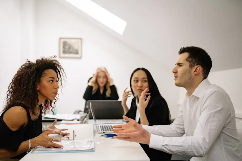 A multi-ethnic team engaged in a heated office discussion, displaying various emotions.