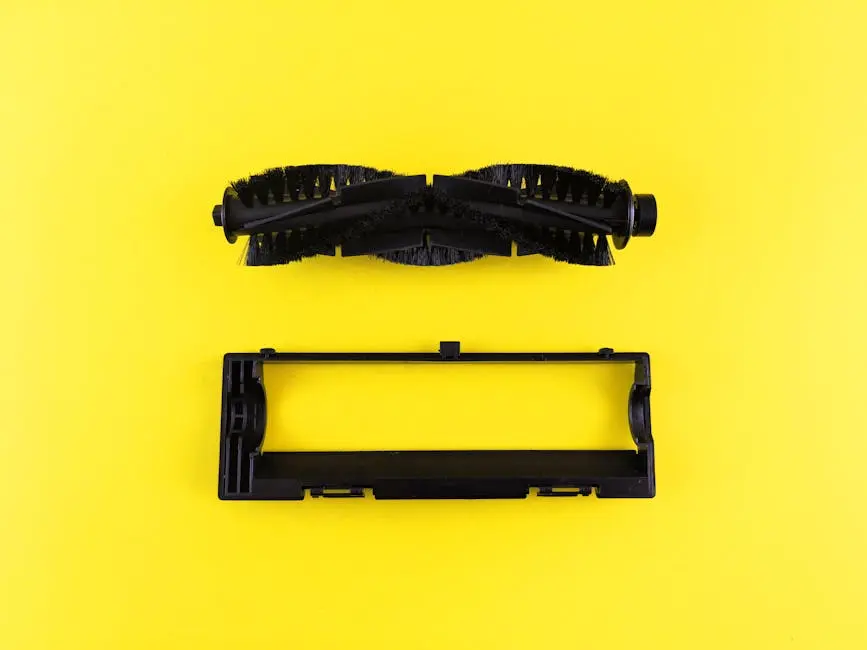 Close-up of vacuum cleaner components on vibrant yellow surface, highlighting maintenance and cleaning.