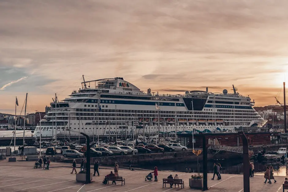 Large cruise ship docked at the promenade during sunset, with people walking nearby.