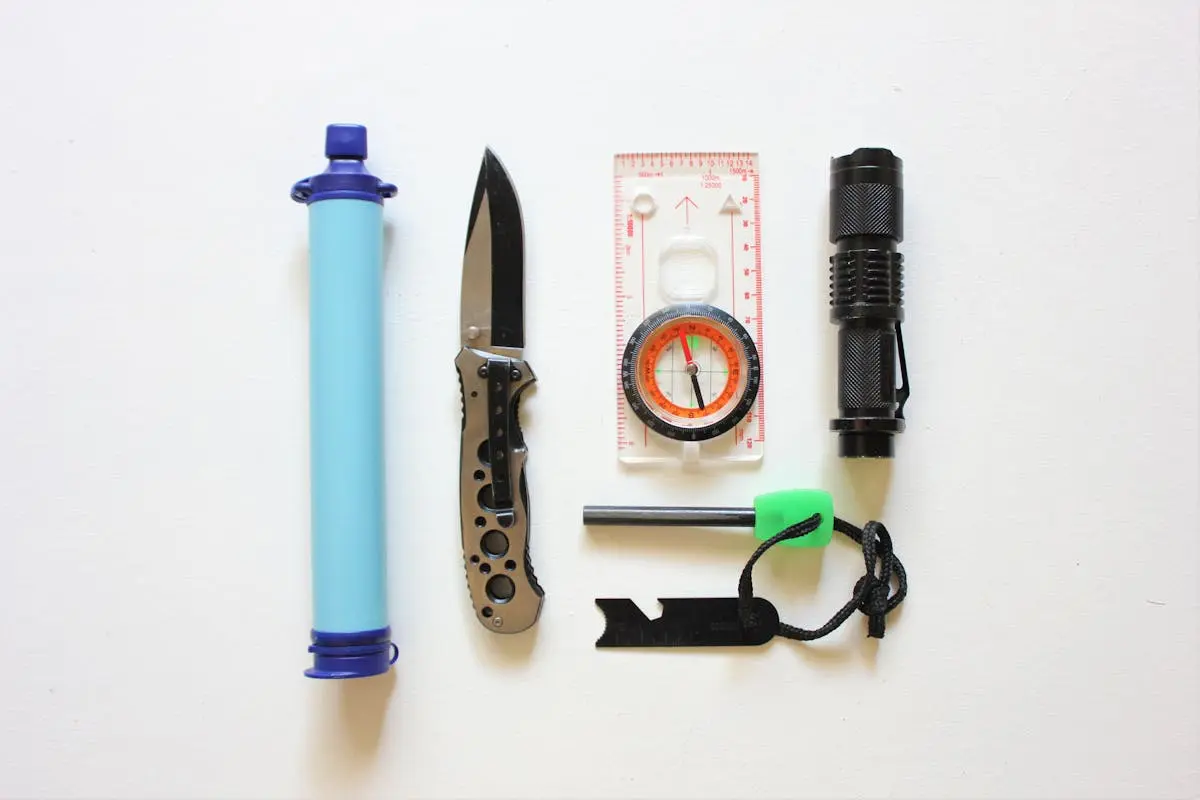 Flatlay of essential survival kit items on a white background