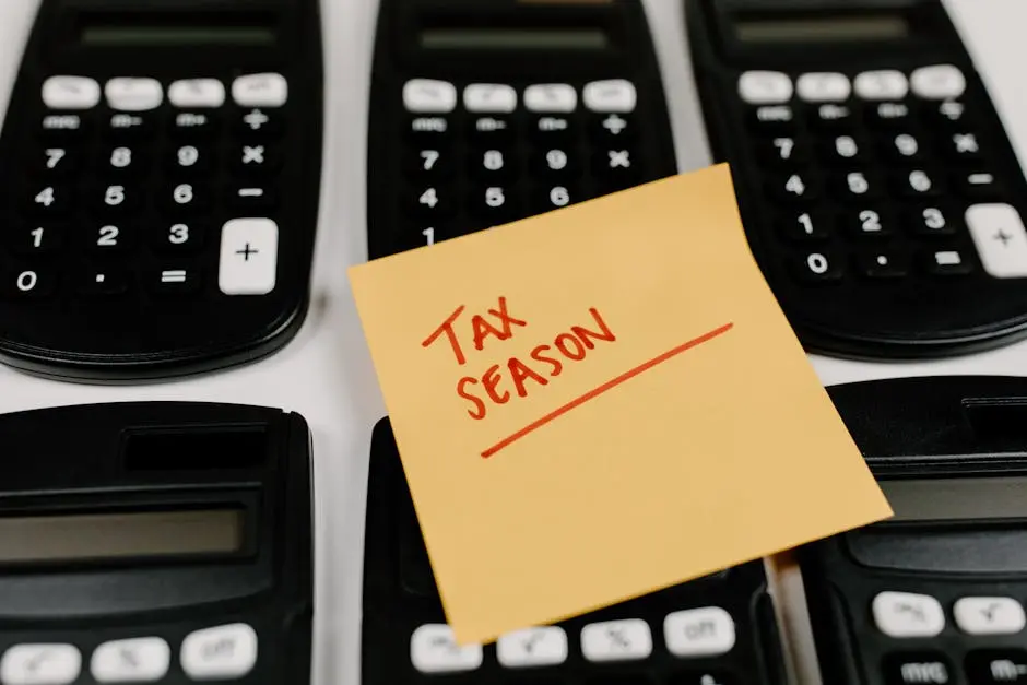 Close-up of calculators and a sticky note labeled ‘Tax Season’, symbolizing tax preparation.