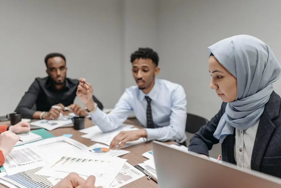 A multicultural team engaged in a productive office meeting, discussing business strategies.