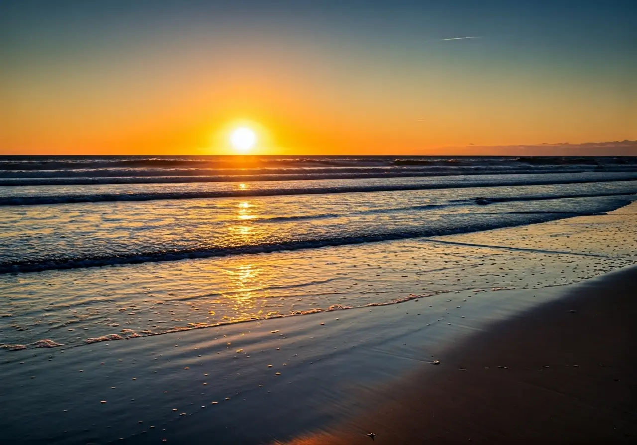 A serene sunrise over a tranquil beach with waves. 35mm stock photo