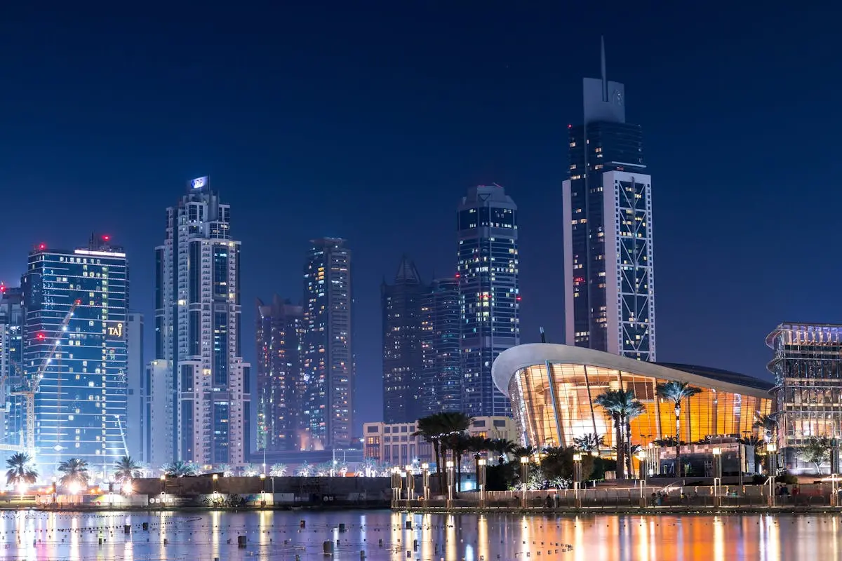 Stunning view of Dubai’s illuminated skyline with modern skyscrapers reflecting on water at night.