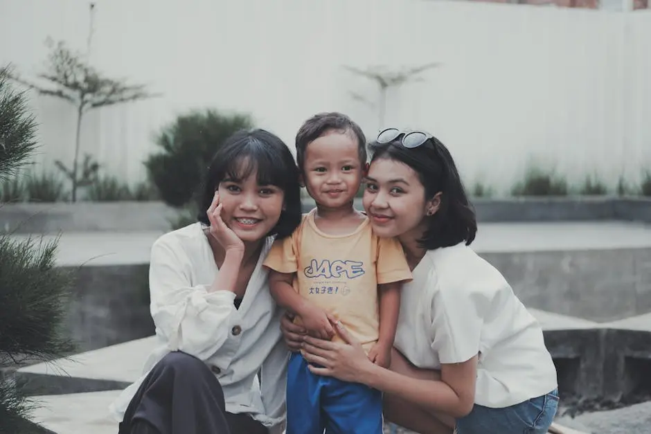 A joyful family moment with two women hugging a smiling child outdoors.