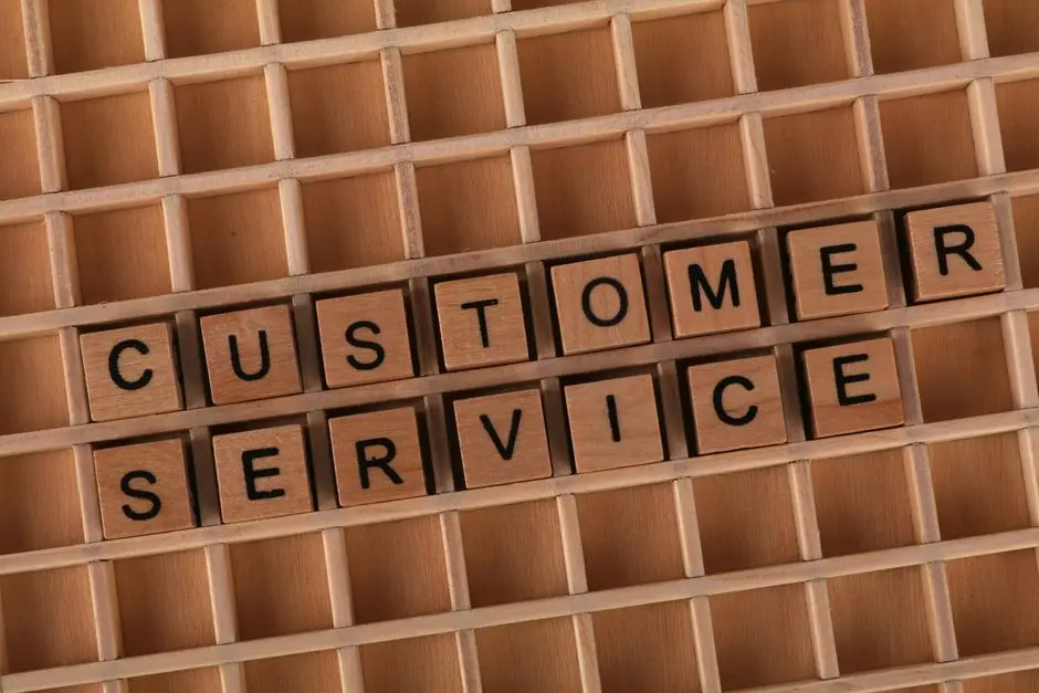 Wooden blocks forming the phrase ‘Customer Service’ placed inside a wooden grid, symbolizing support and assistance.