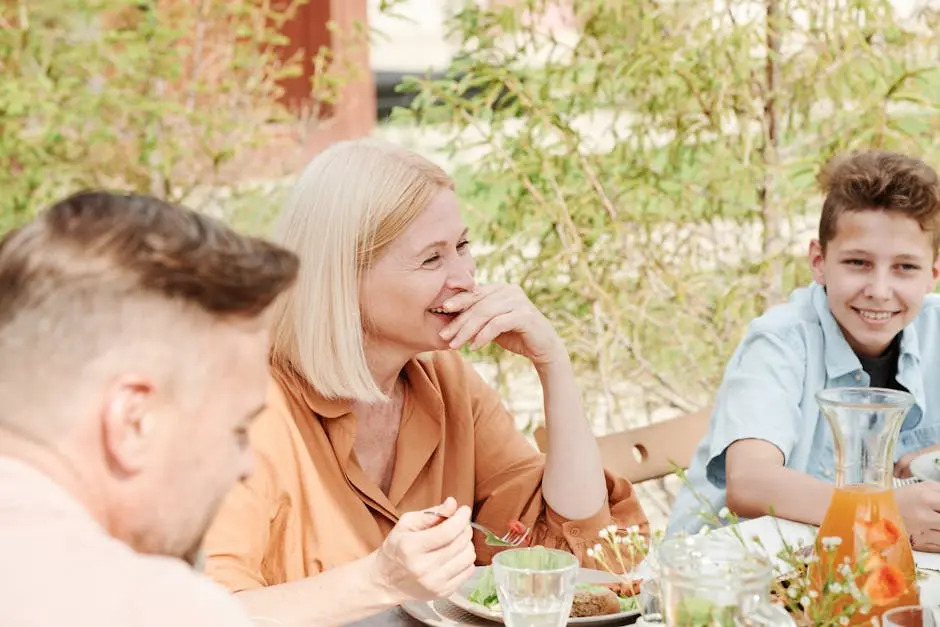 A cheerful family enjoying a meal together in a serene outdoor garden setting.