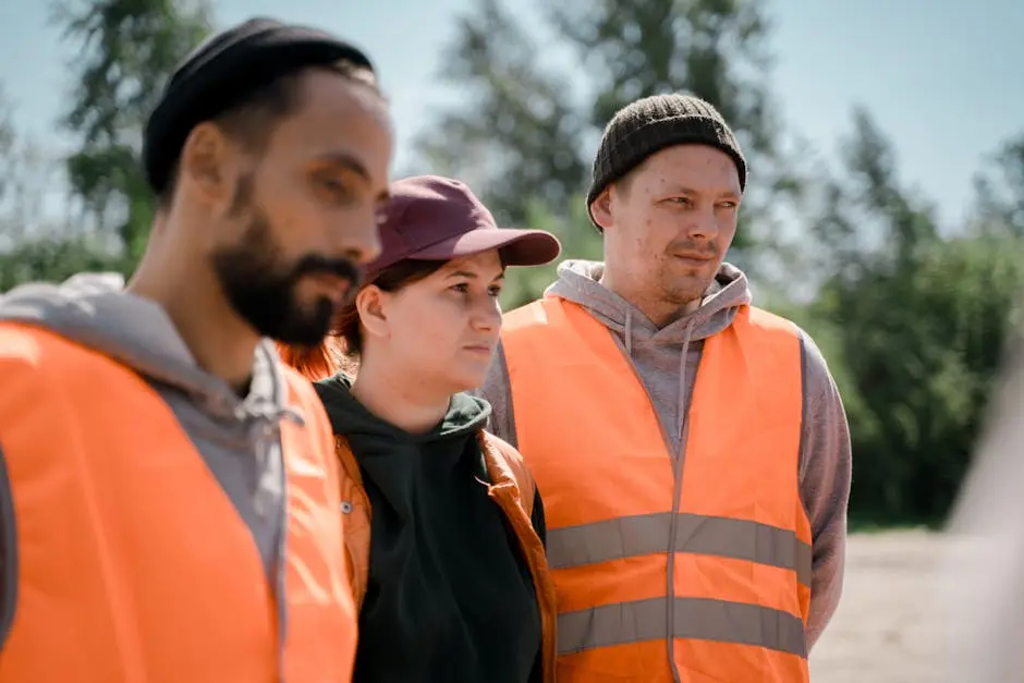 Group of workers wearing reflective vests outdoors, exemplifying teamwork and safety.