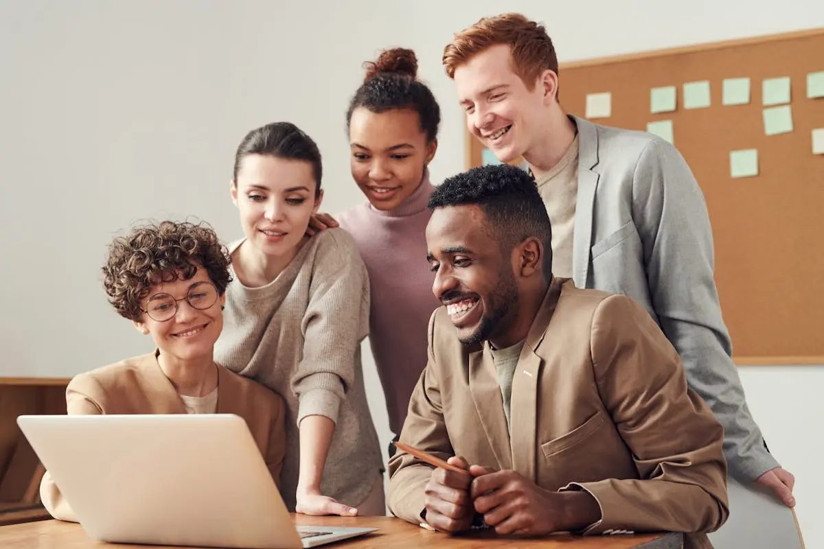 A group of diverse young professionals happily collaborating around a team leadership.
