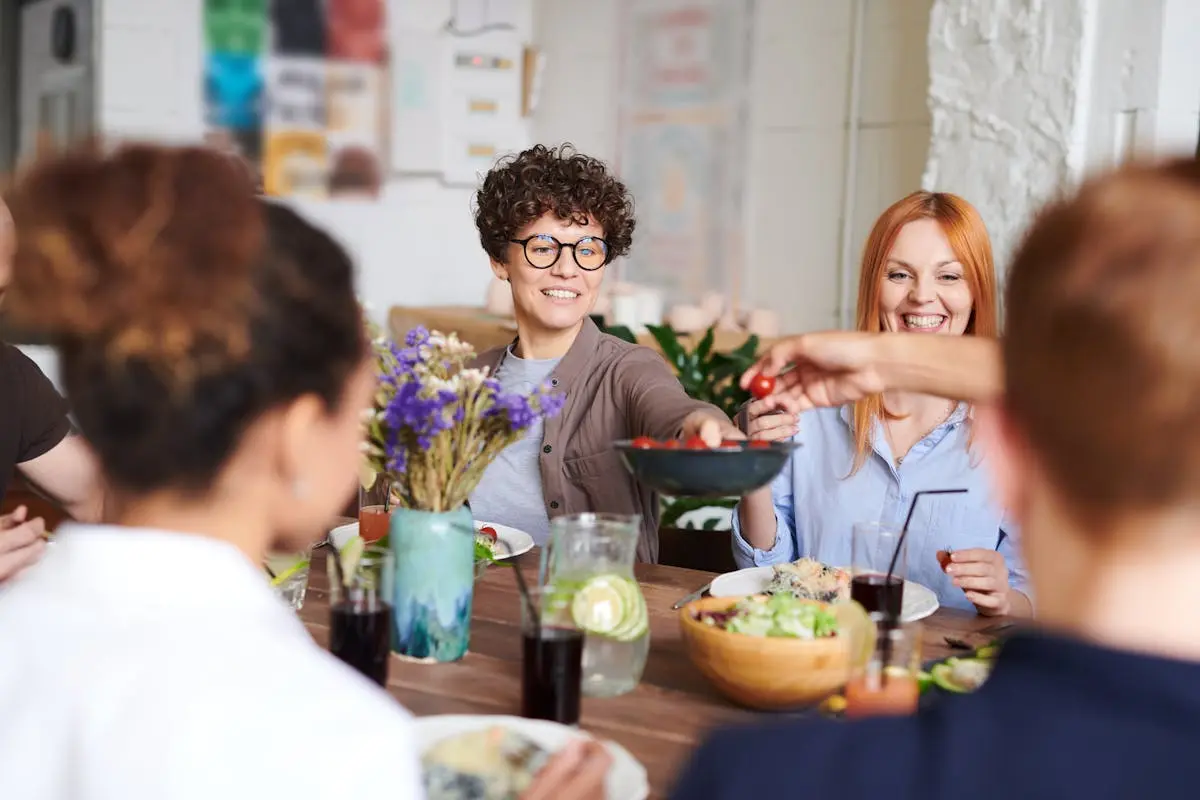 Group of friends smiling at a restaurant table with food