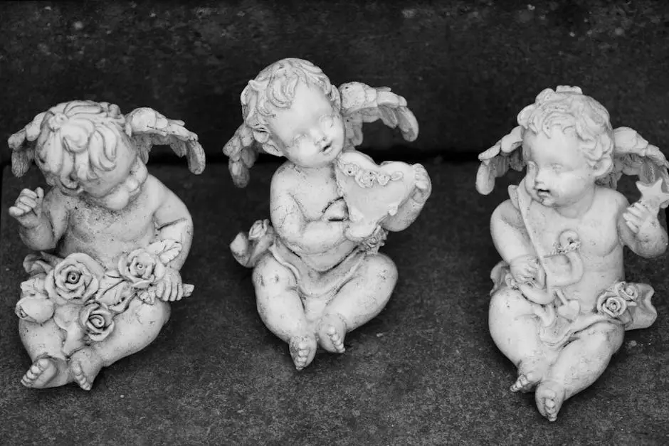 A serene black and white photo of three marble cherub statues sitting gracefully, embodying angelic art.