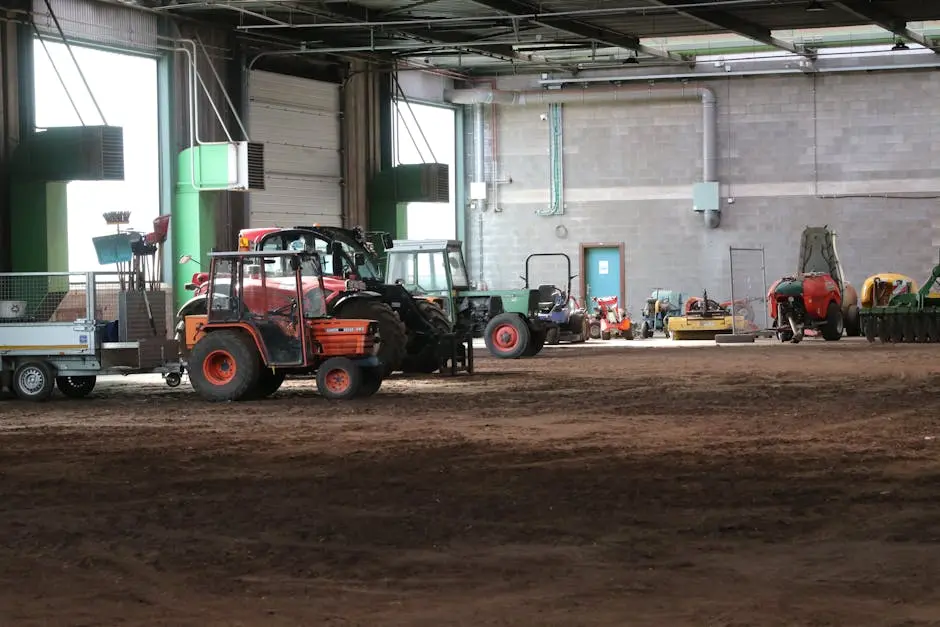 Image of various tractors and farm machinery stored in a large indoor facility.