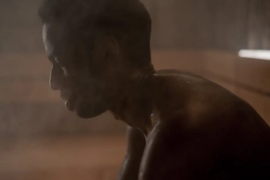 Side view of an adult man relaxing in a steamy sauna, focusing on wellness and self-care.