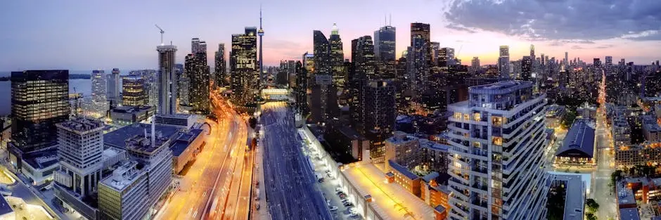 High-rise view of Toronto city skyline at dusk with vibrant city lights and roads.