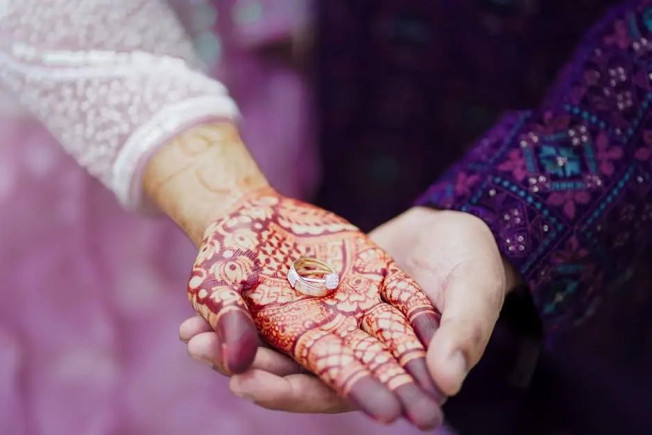 Close-up of a couple’s hands, adorned with Mehndi and wedding rings, showcasing love and tradition.