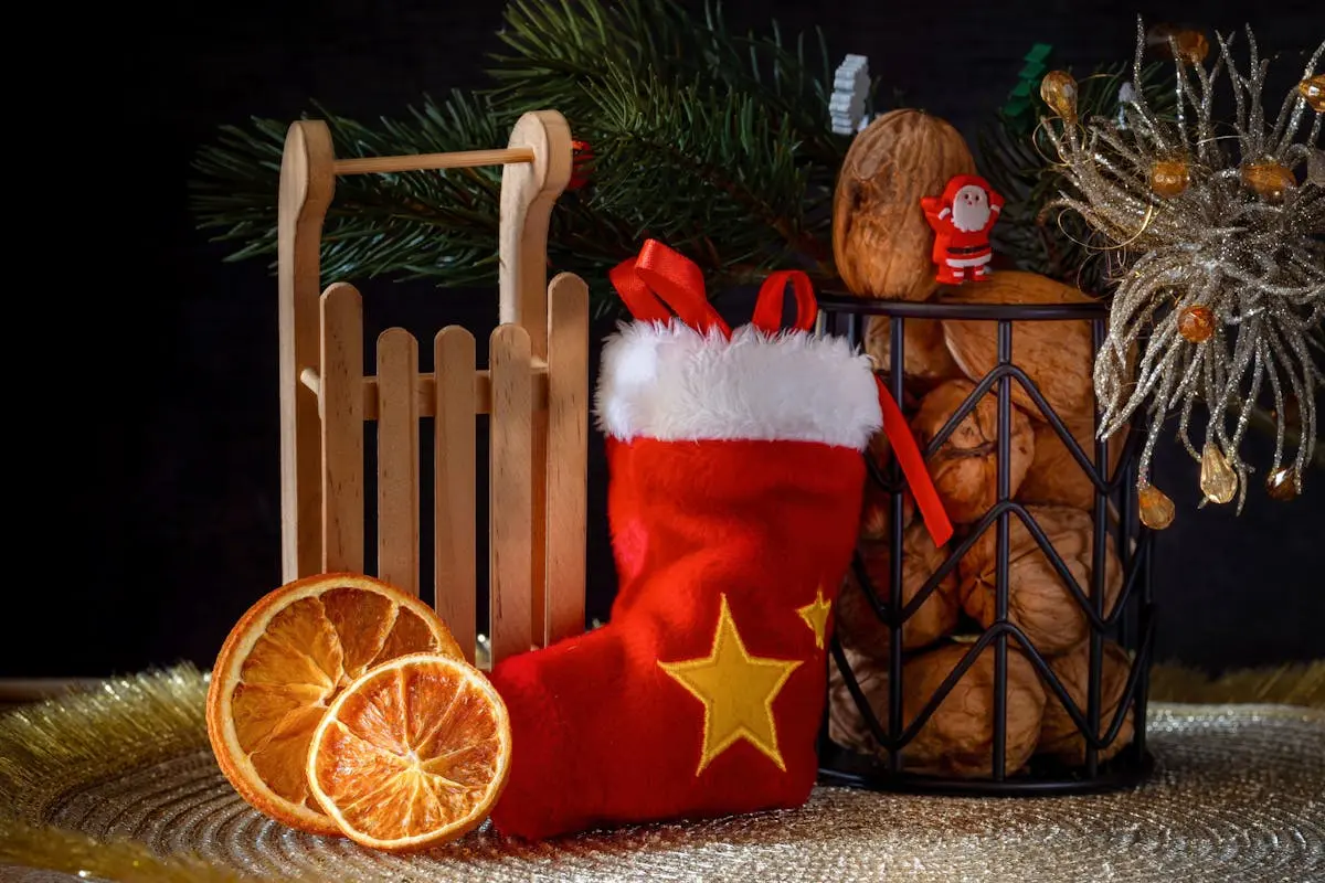 A cozy Christmas still life featuring a stocking, sled, and festive decorations.