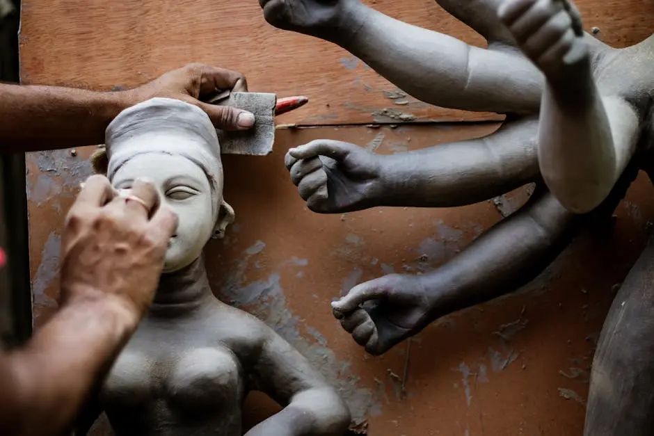 Close-up of an artisan sculpting a multihanded statue with great precision.