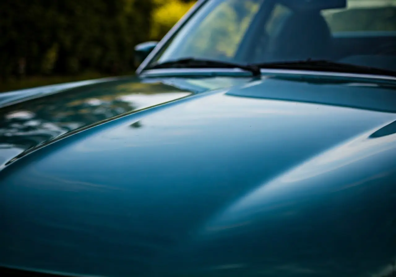 Close-up of a car hood reflecting a clear blue sky. 35mm stock photo