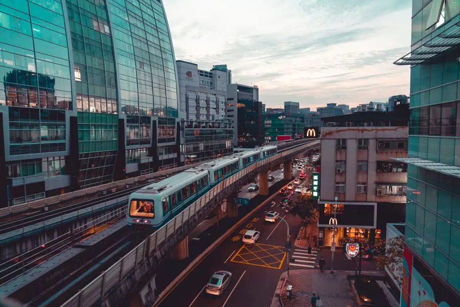Dynamic cityscape featuring an elevated train amidst modern architecture and busy streets.