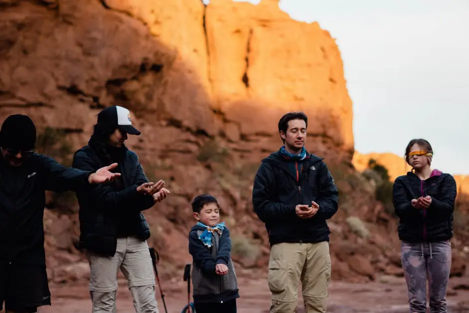 A diverse group meditates in the tranquil desert sunrise, embracing peaceful reflection.