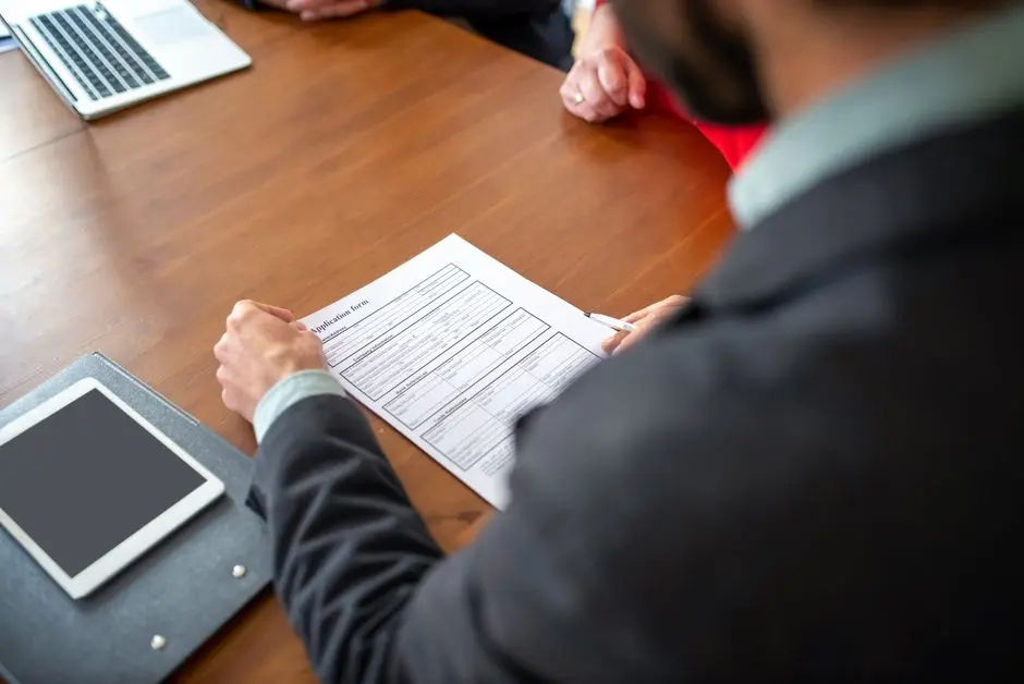 Business professionals reviewing an application form during a meeting.