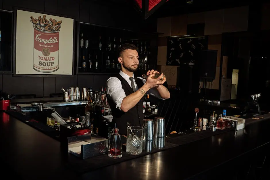 Bartender skillfully mixing cocktails in a contemporary bar with artistic decor.