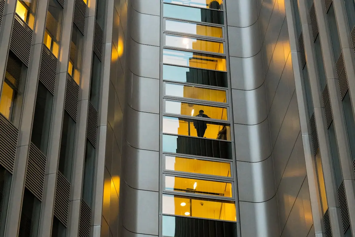 Reflection of a person in a modern Berlin building’s glass facade with sleek architecture.