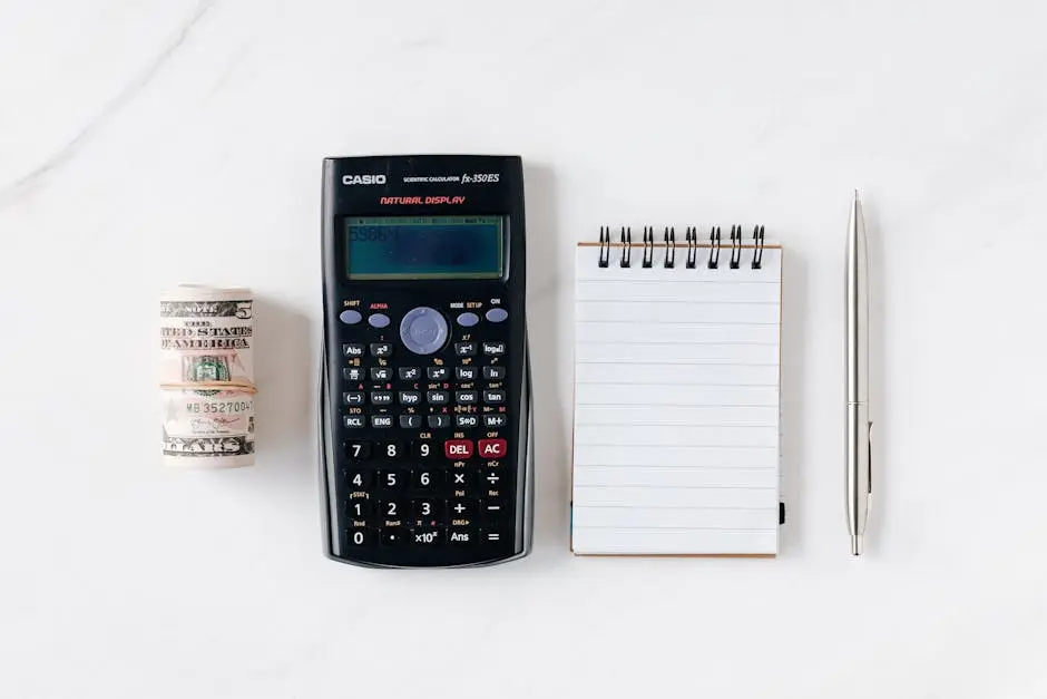 Top view of financial tools including a calculator, notepad, pen, and rolled cash on a white background. How to Buy a Small Business with No Money