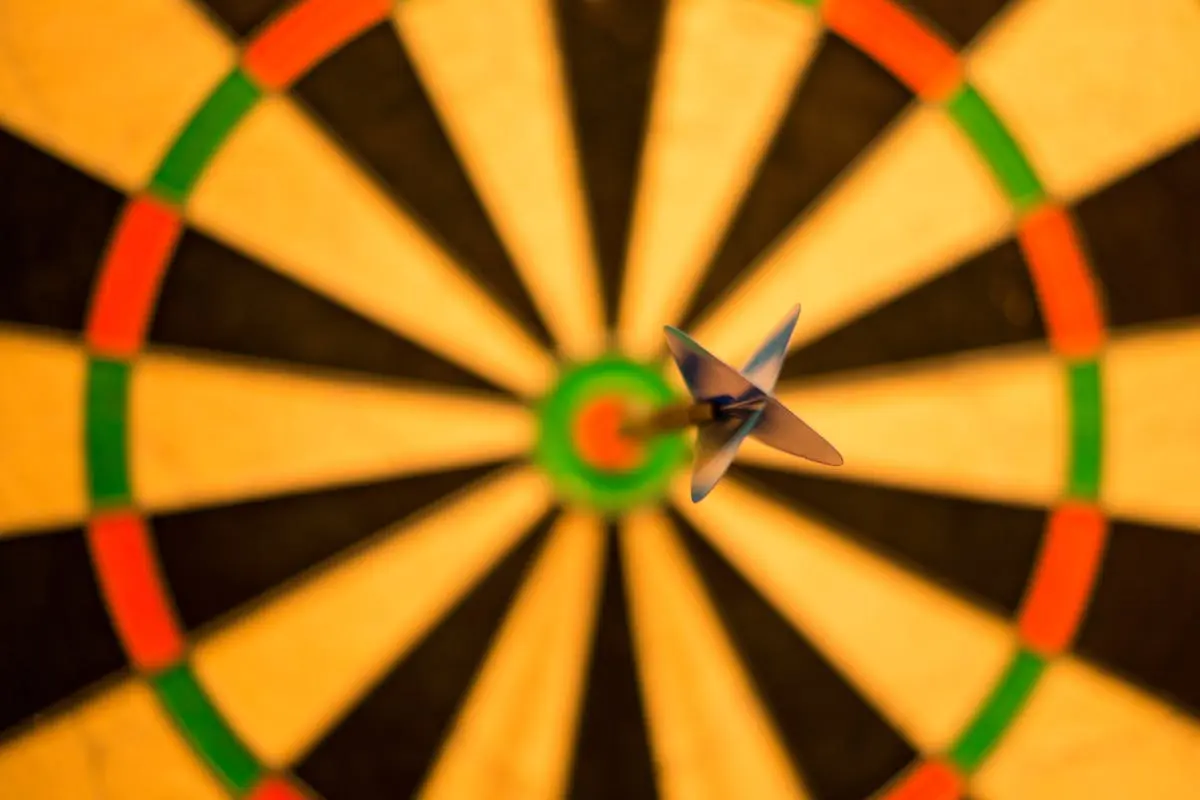 A close-up of a dart perfectly hitting the bullseye on a dartboard, symbolizing accuracy.
