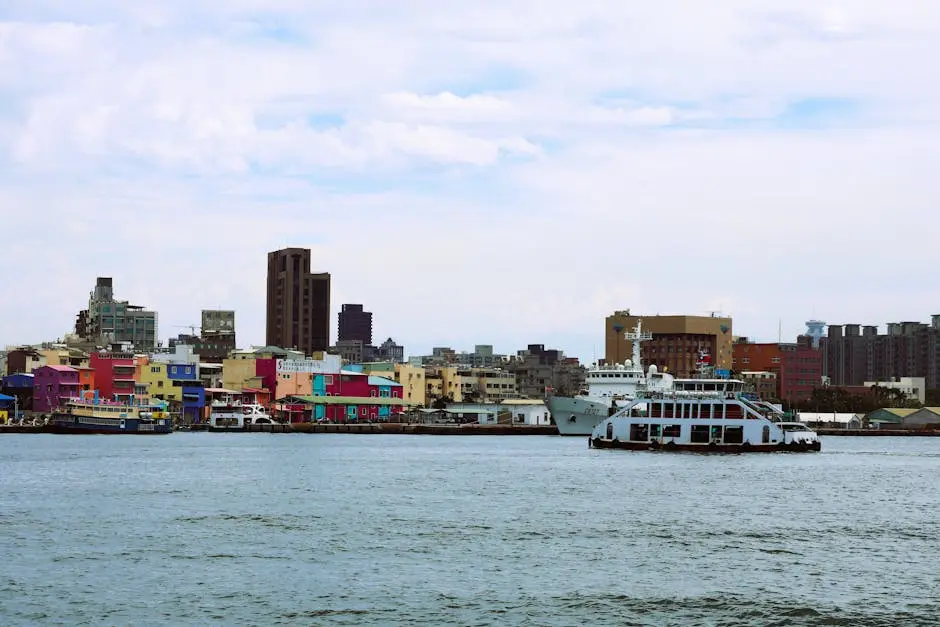 Colorful waterfront view of Kaohsiung, Taiwan with ferry crossing the harbor.
