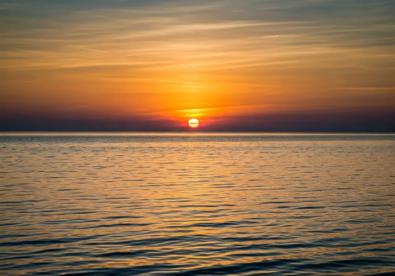 A serene sunset over a calm ocean horizon. 35mm stock photo