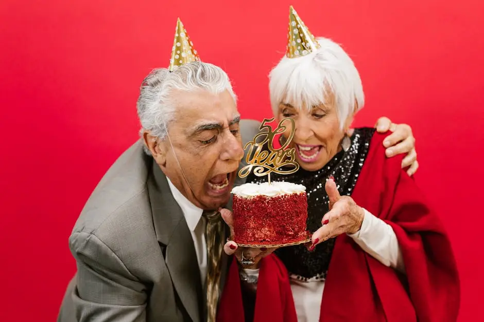 Cheerful elderly couple celebrating their 50th anniversary with a festive cake and joy.