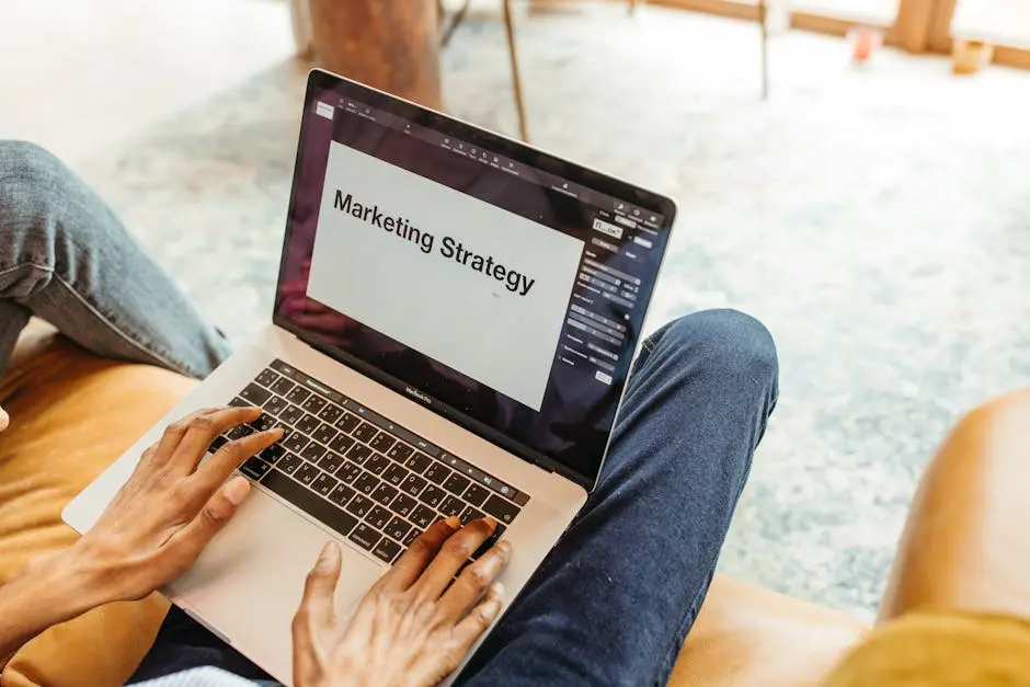 Close-up of hands using a laptop displaying a marketing strategy presentation indoors. Brand Enhancement 