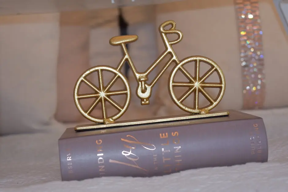 Artistic golden bicycle figurine displayed on a book, perfect for decor inspiration.