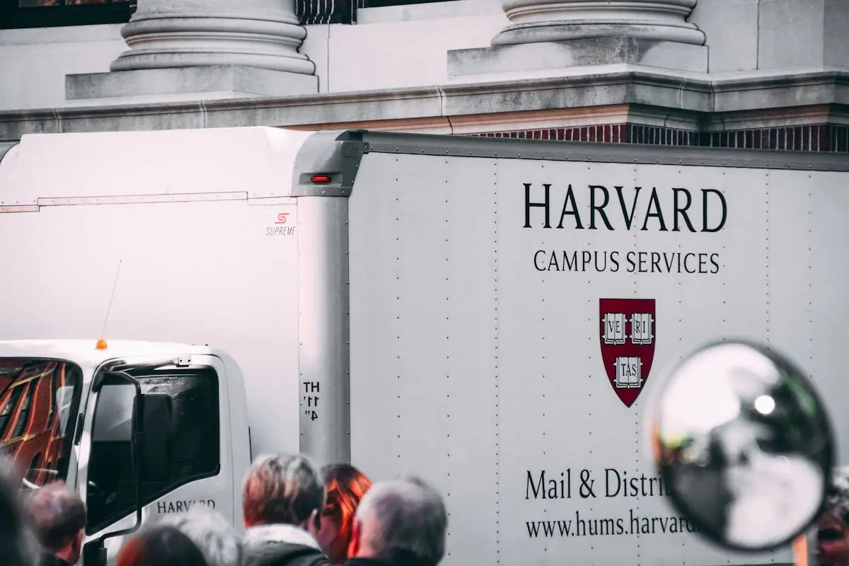 Harvard Campus Services truck in city street, showcasing delivery near university building.