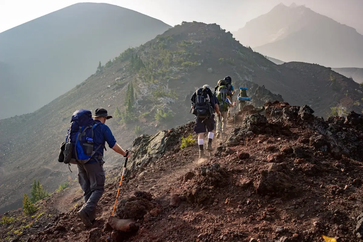 Group of hikers trekking on a rugged mountain trail in Oregon’s scenic outdoors.