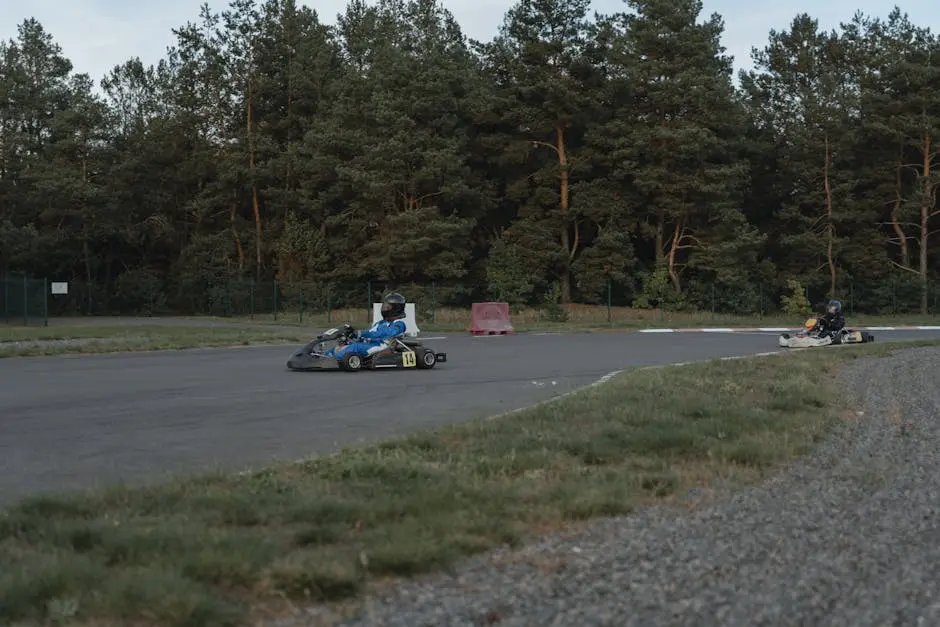 Two go-karts race on an outdoor track surrounded by trees, showcasing thrilling motorsport action.