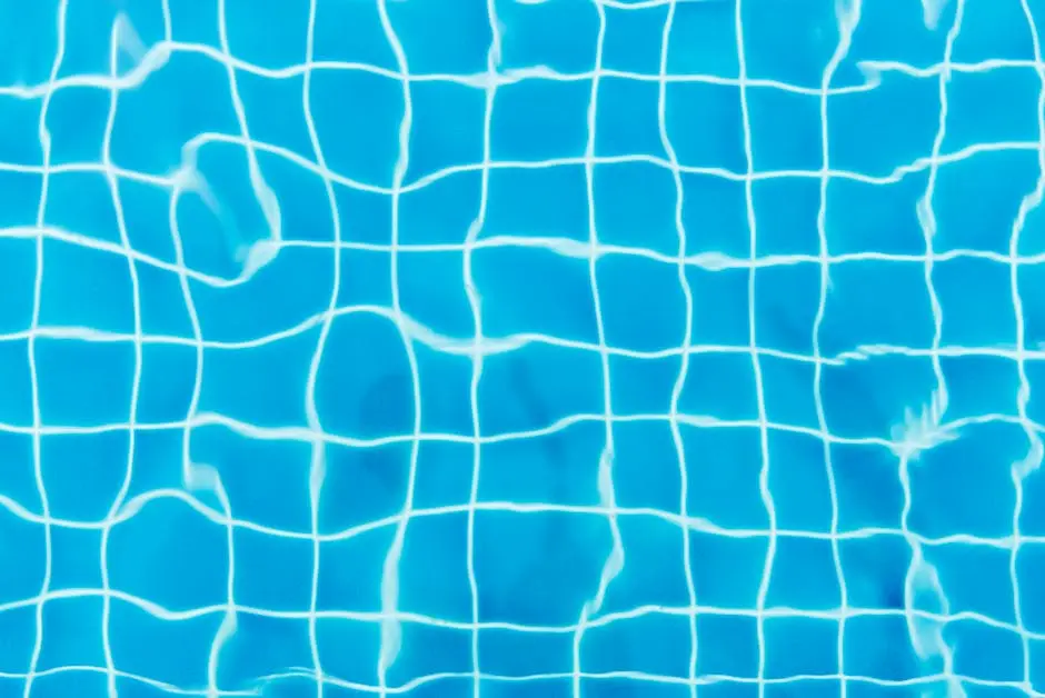 Top view of a swimming pool with vibrant blue water and tile patterns.