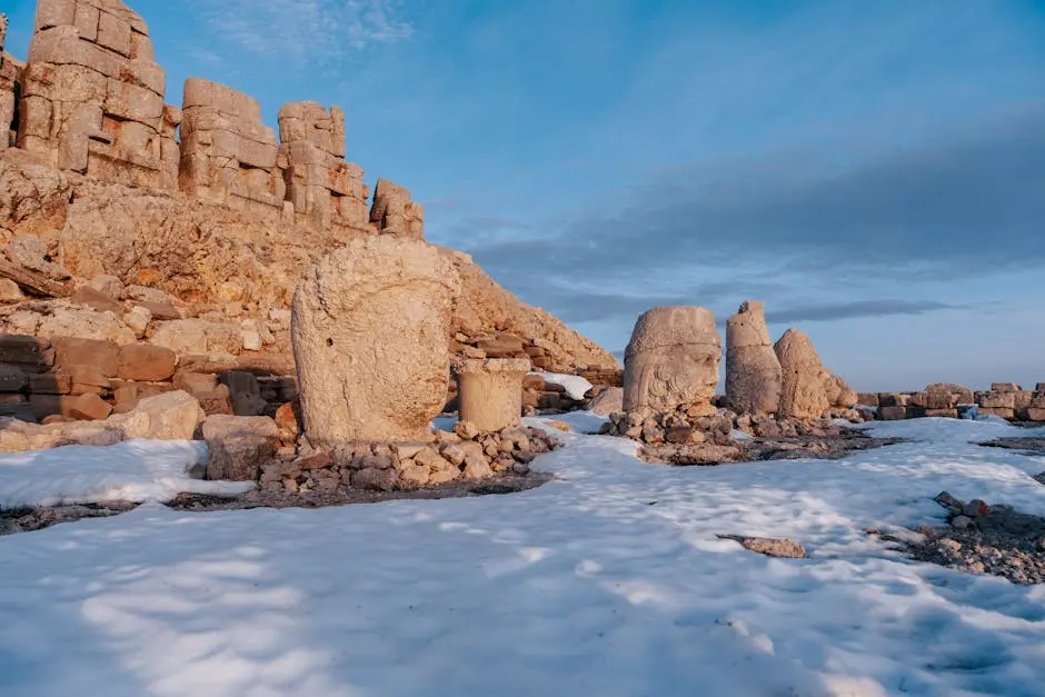 Historic stone sculptures in snowy landscape at Mount Nemrut, Turkey.