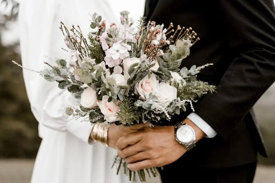 Close-up of a wedding bouquet held by bride and groom, showcasing romance and elegance.