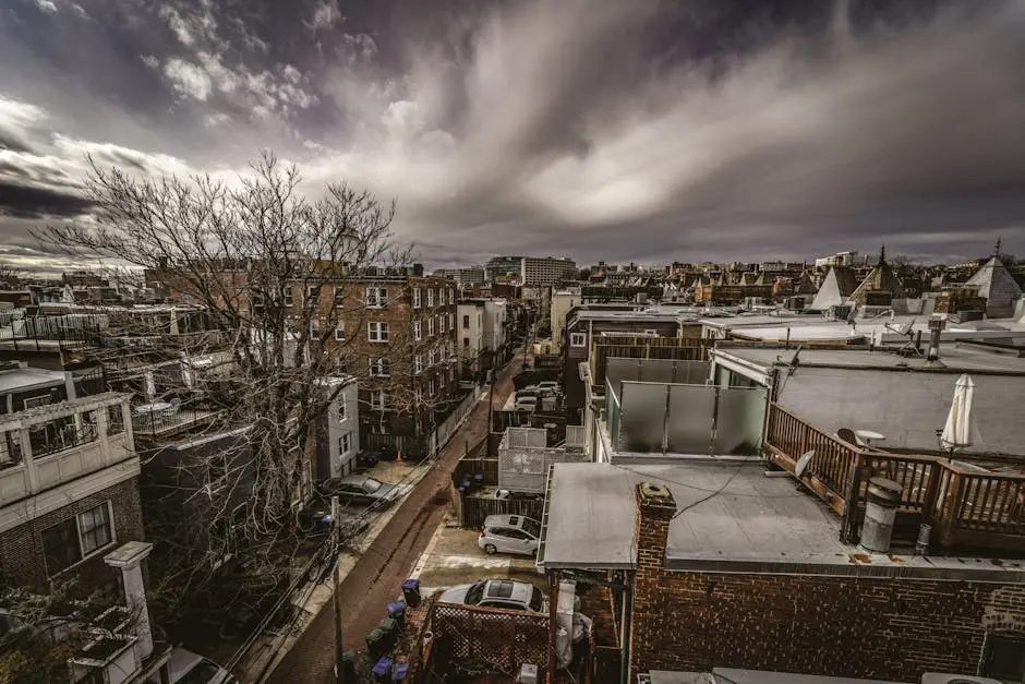 A dramatic aerial view of Washington DC’s urban streets and architecture under a cloudy sky.