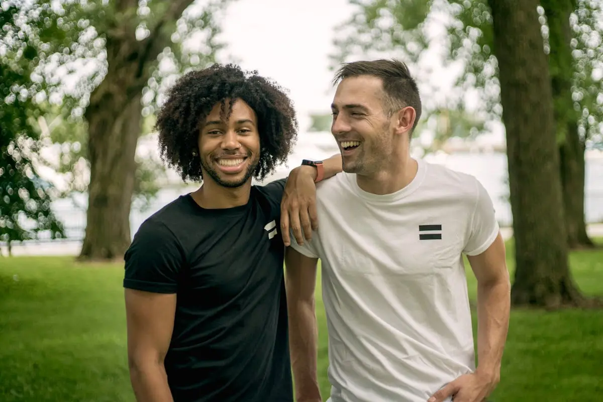 Two friends laughing and enjoying a sunny day at a park in Chicago.