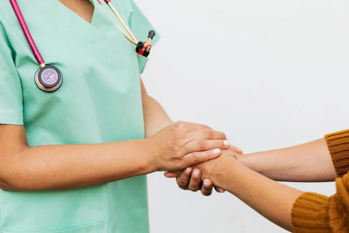 Close-up of a doctor holding a patient&rsquo;s hands, symbolizing trust and empathy in healthcare.